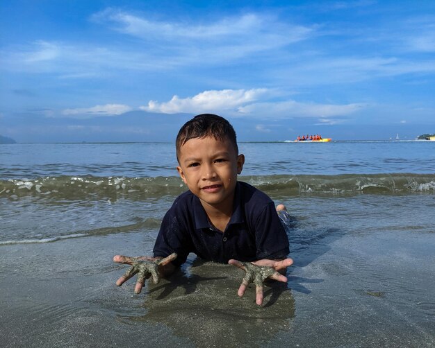 A child is enjoying playing in the sea water on the beach