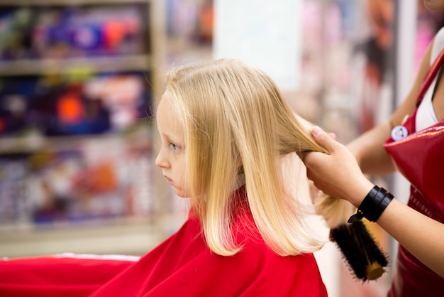 A child is given a haircut in a beauty salon.