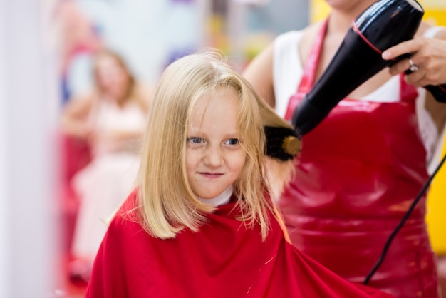 A child is given a haircut in a beauty salon.