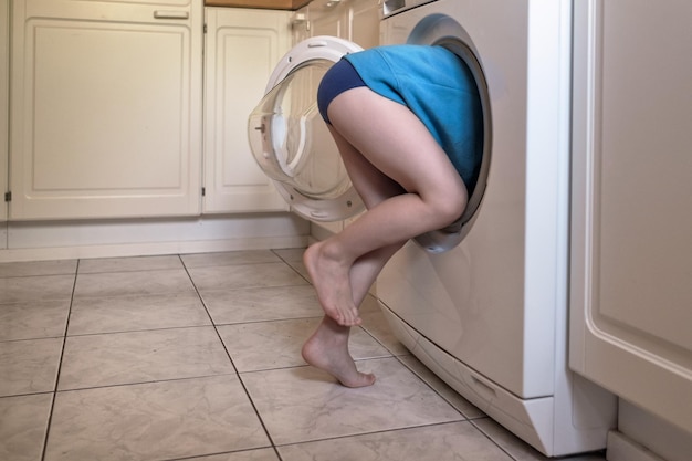 Child is hiding into the washing machine