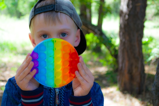 Il bambino tiene in mano un pop e una passeggiata all'aria aperta riposati dai gadget moderni