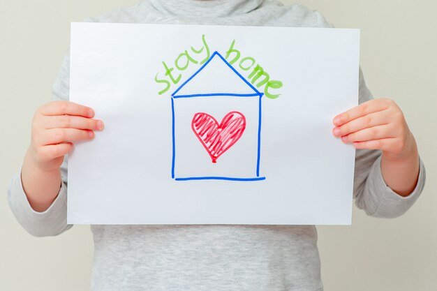 Child is holding picture of house.