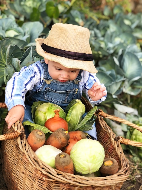 The child is a little farmer. Farm assistant.