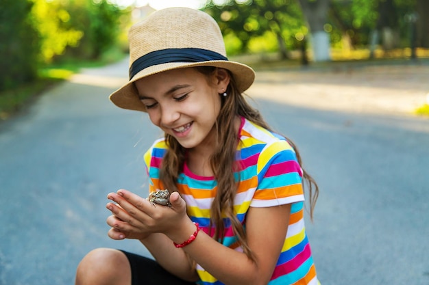 子供はカエルと遊んでいます セレクティブ フォーカス