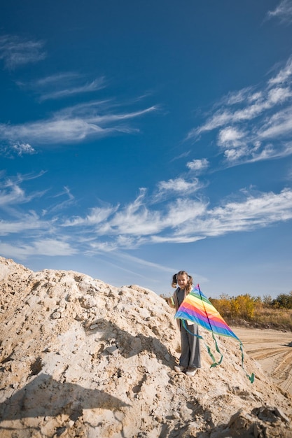 A child is playing with a kite in the sand 3333