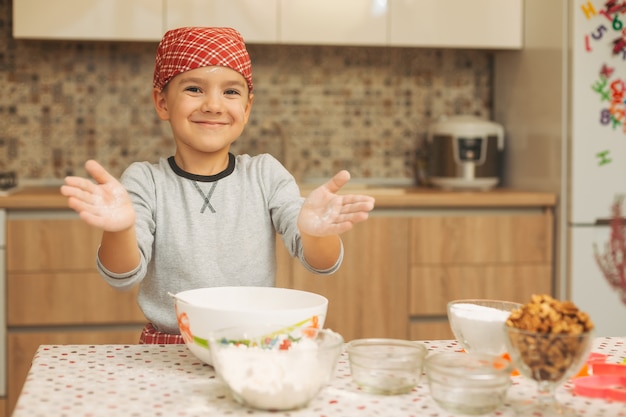 Child is preparing the dough, bake cookies in the kitchen