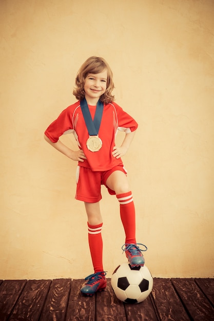 Child is pretending to be a soccer player. Success and winner concept