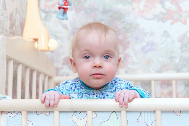 A child is standing in a crib