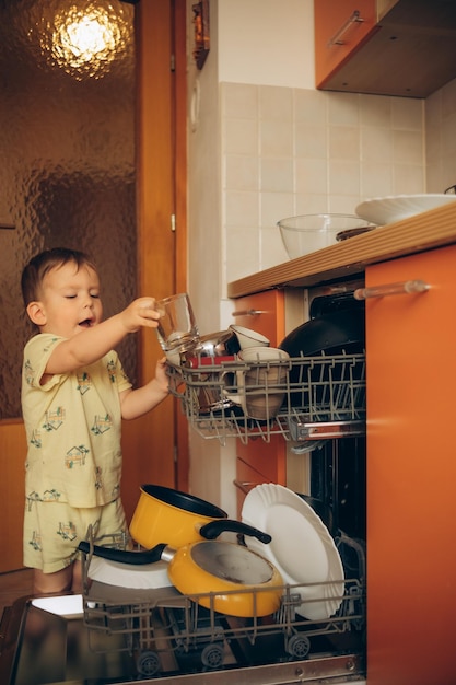 Photo a child is trying to pull a dishwasher.