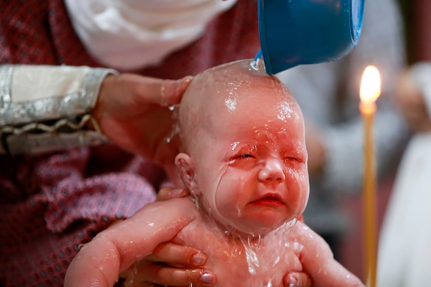 子供は水で水をまきます。新生児の洗礼