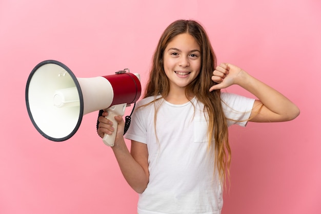 Ребенок над изолированной розовой стеной держит мегафон и горд и самодоволен