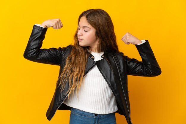 Child over isolated yellow background doing strong gesture