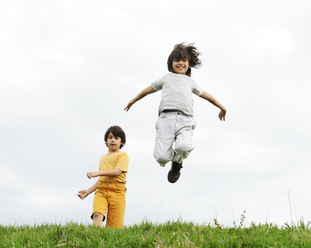 Child jumping on a green meadow