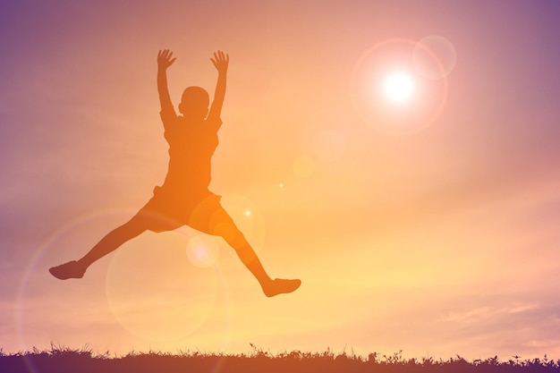 Child jumping at sunset