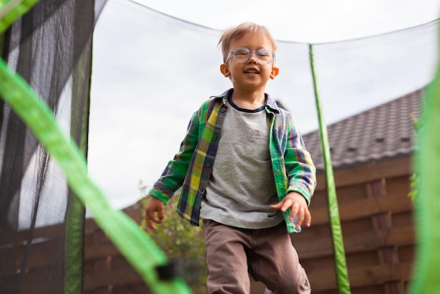 裏庭でトランポリンにジャンプする子供