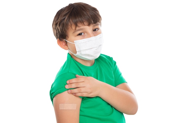 Child kid with plaster after Coronavirus vaccination wearing face mask against Corona Virus COVID19 Covid isolated on white