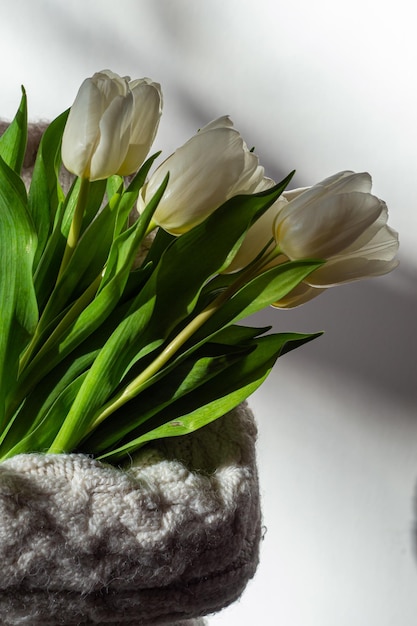 Photo a child in a knitted sweater holds a bouquet of tulips