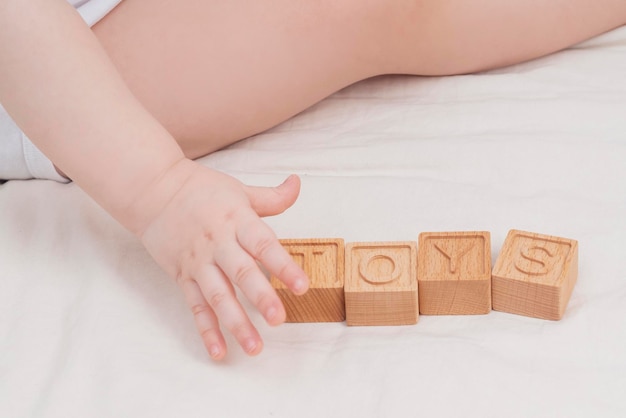The child laid out the word toys made of wooden cubes closeup A small child learns the English alphabet learns to read Early child development educational games