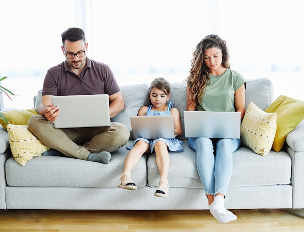 Child laptop family computer woman mother father happy home man technology daughter together internet