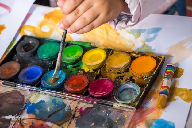 Bambino che impara a dipingere con i colori ad acqua