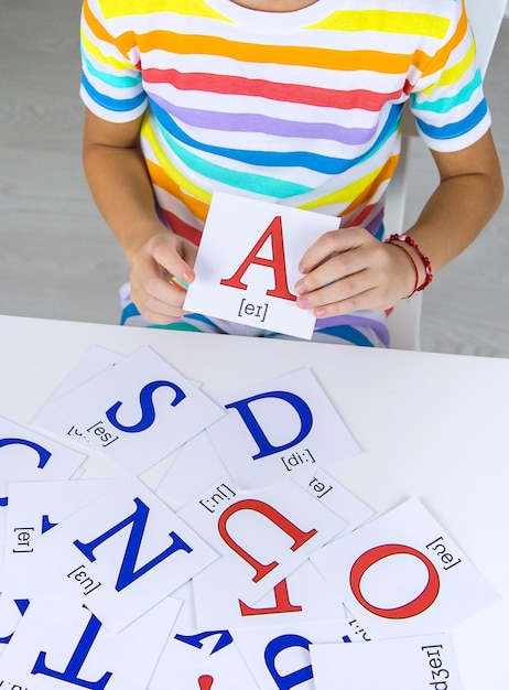 Foto il bambino impara le lettere inglesi messa a fuoco selettiva