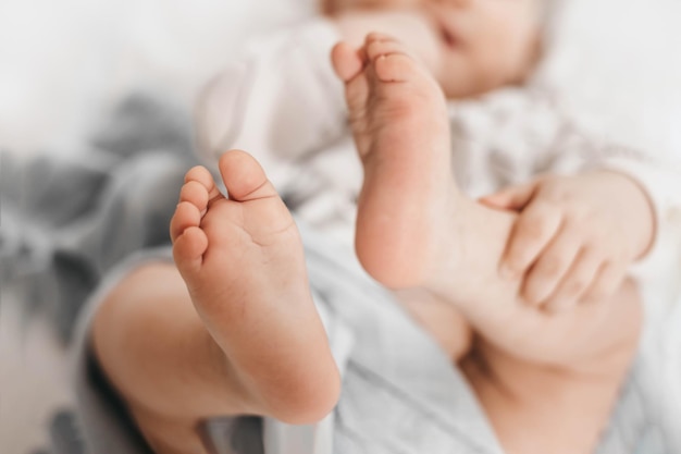 子供は足を上げて毛布でベッドに横になります子供の脚の運動能力の発達