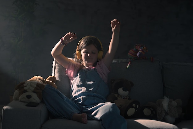 Photo child listening to music and dancing on sofa