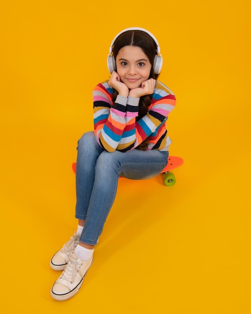 Child listening music with headphones Girl listening songs via wireless earphones Headset device accessory Stylish teenage girl listening to music Urban kids style stylish hipster teen