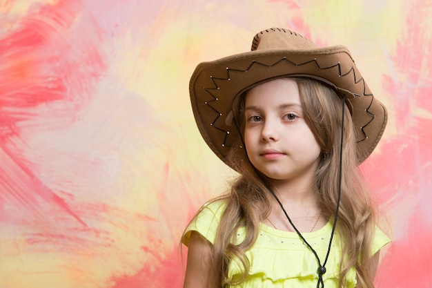 Child, little girl in cowboy hat on colorful background, copy space