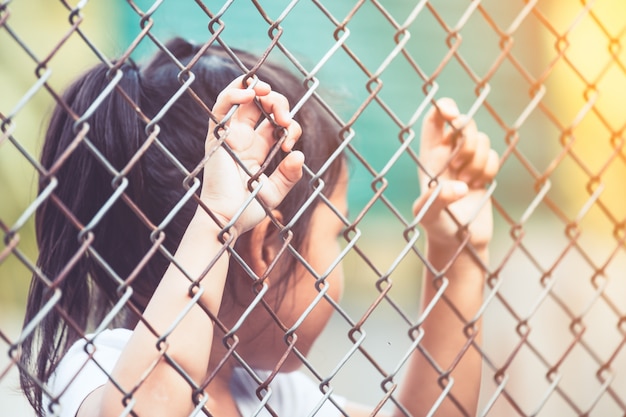 Child little girl hand holding steel mesh in vintage color tone