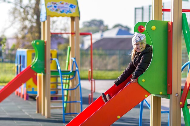 Child little pretty girl playing on playground outdoors