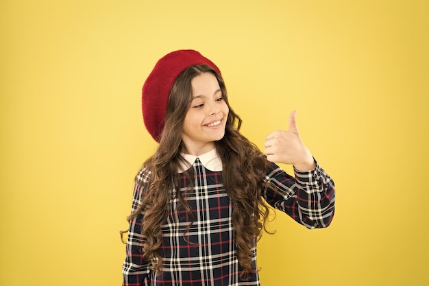 Child long curly hair wearing hat Happy schoolgirl stylish uniform Happy childhood concept Happy smiling cheerful kid portrait Small girl nice hairstyle Cool girl Fashion shop Fancy accessory