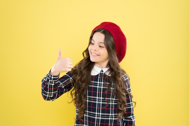 Child long curly hair wearing hat. Happy schoolgirl stylish uniform. Happy childhood concept. Happy smiling cheerful kid portrait. Small girl nice hairstyle. Cool girl. Fashion shop. Fancy accessory.