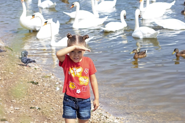 Child looking at camera on swan pond