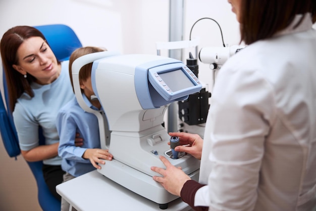 Child looking at the oculars of an automated refractor