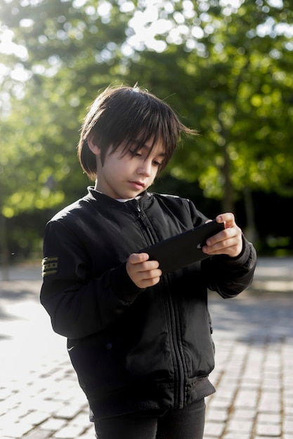 child looking at something on the cell phone in the park