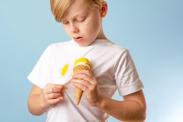 Un bambino che guarda un gelato che si rovescia in un cono su vestiti bianchi. vestiti che si rovinano