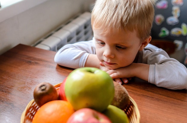 The child looks for fruit and smiles.