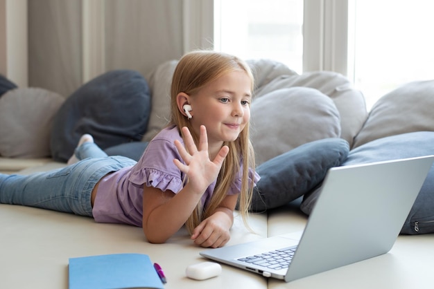 A child looks at a laptop, gestures, an online lesson with a\
speech therapist teacher