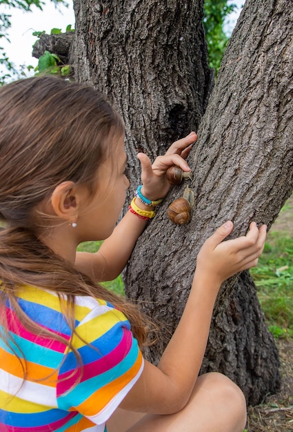 The child looks at the snail Selective focus