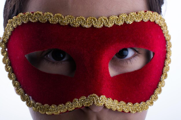 Child looks through carnival mask