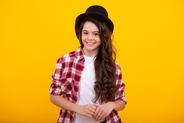 Child in magician hat cylinder hat isolated on yellow background