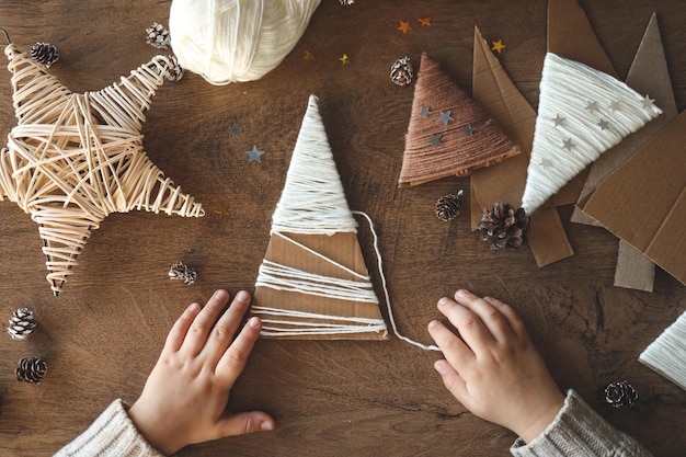 写真 子供が糸でクリスマスの装飾を作る