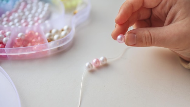 Child makes decoration from beads creative concept