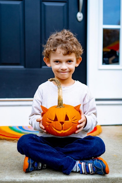 子供はハロウィーンのためにカボチャを作ります