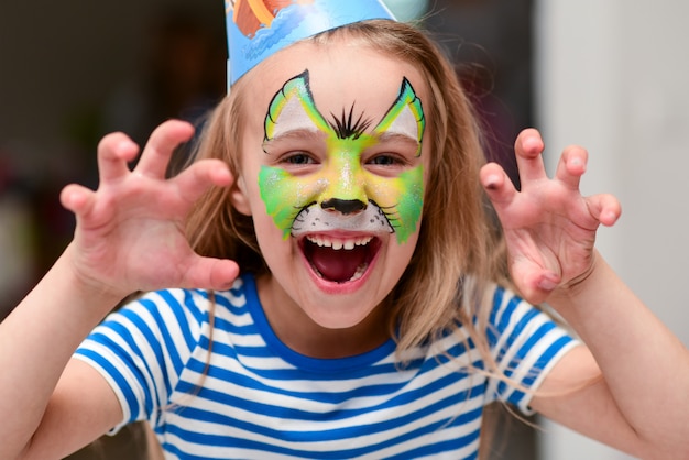 Child in makeup growls with claws hands