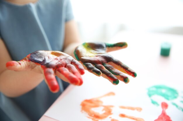 Photo child making hand prints on paper