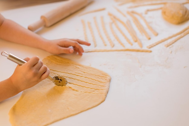 写真 子供がキッチンで自家製のパスタを作っている