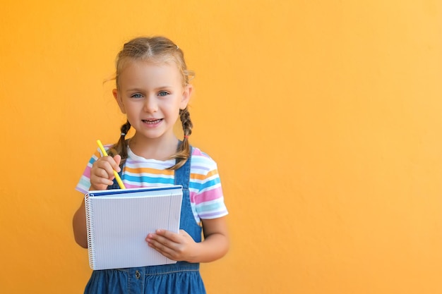 Child making notes. Kids dreams.Isolated on yellow background.Education products goods