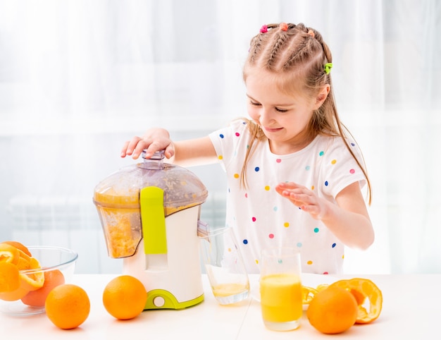 Bambino che produce il succo d'arancia